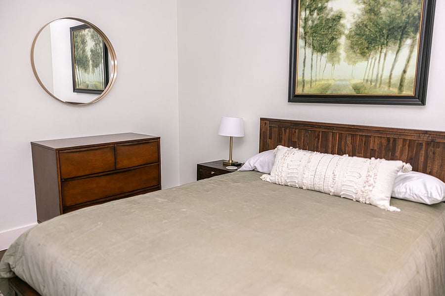 Second Bedroom with Queen Puffy bed, fully furnished with headboard, night tables / lamps, dresser, area rug, and full-sized wall closet (not shown).