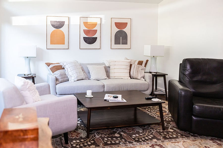 Living area furnished with sofa, chair, leather recliner, coffee table, and two end tables.