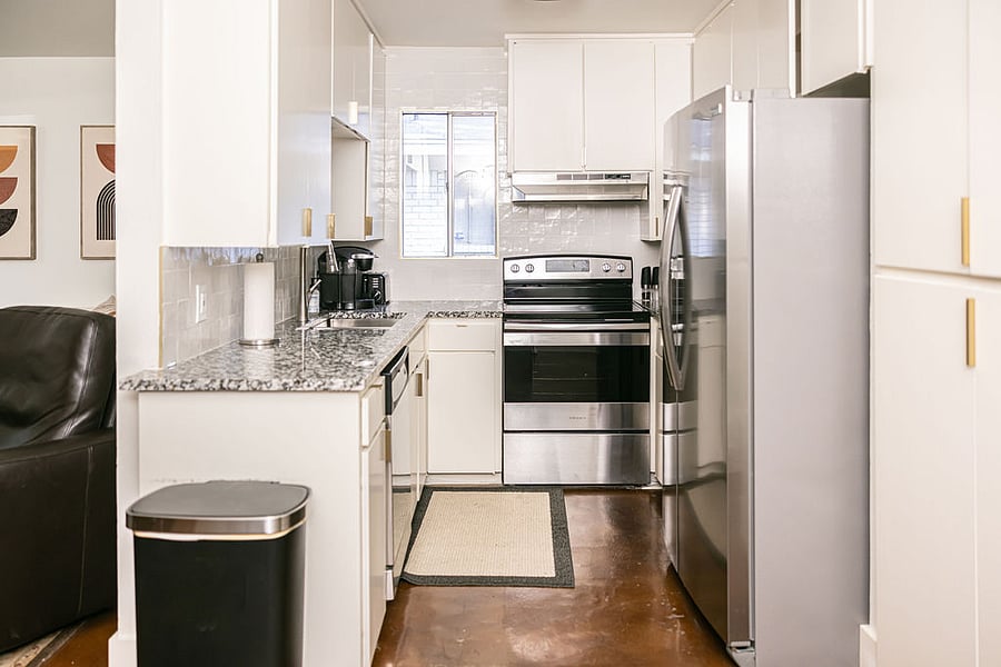 Kitchen: Electric oven / range with stainless vent-a-hood.