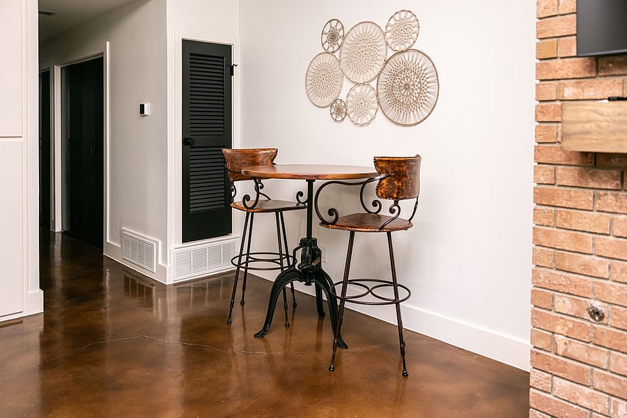 Dining area: Adjustable industrial, circular dining table with hammered copper surface. Two leather & iron dining high-chairs.