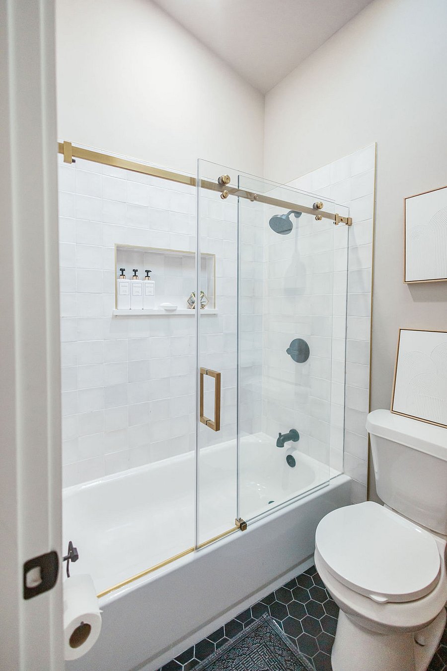 Secondary bathroom with glass sliding doors.