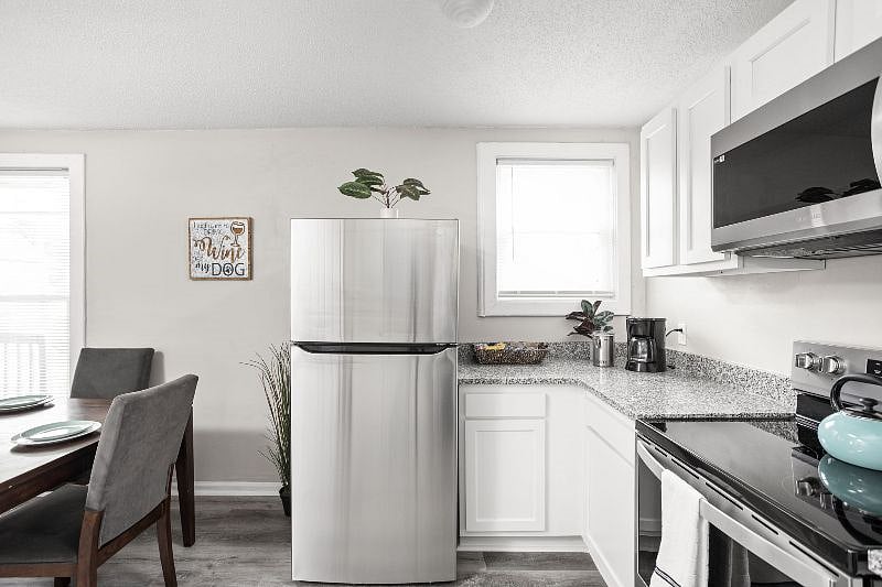 The kitchen is neat and fully equipped with utensils and appliances.
