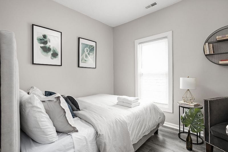 This bedroom has a queen bed, window and chair to add to the ambiance, enhancing relaxation.