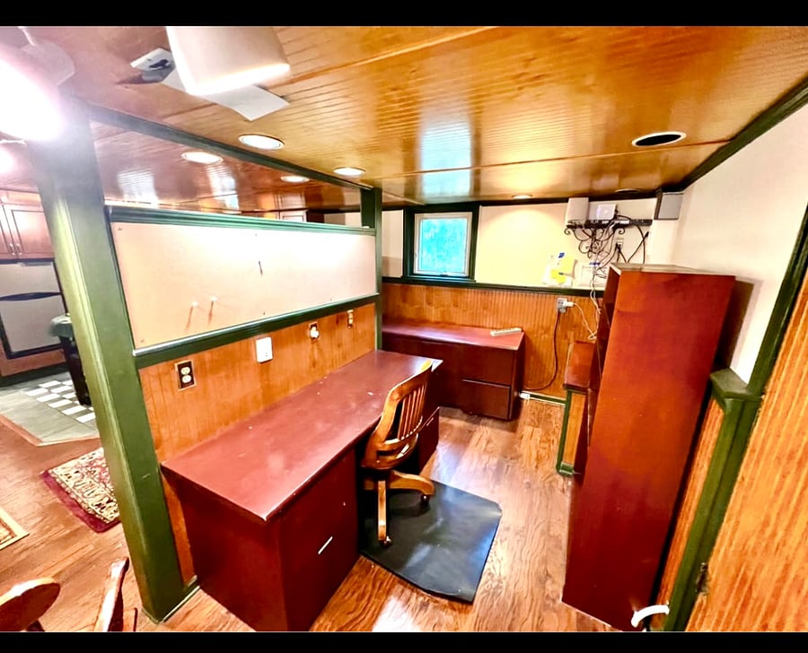 Office space includes desk, credenza, shelving, and entire wall devoted to white board