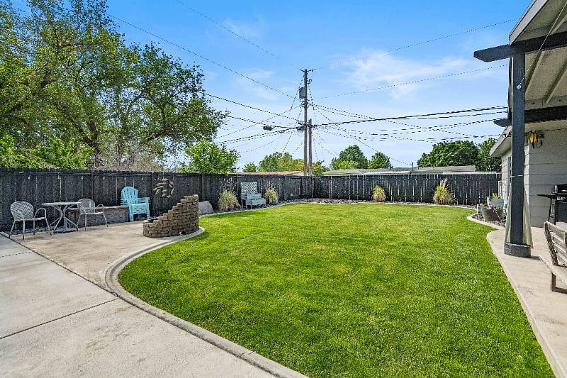 Backyard with fire pit, underground sprinklers and auto on/off lights along fence creating a wonderful ambiance to enjoy