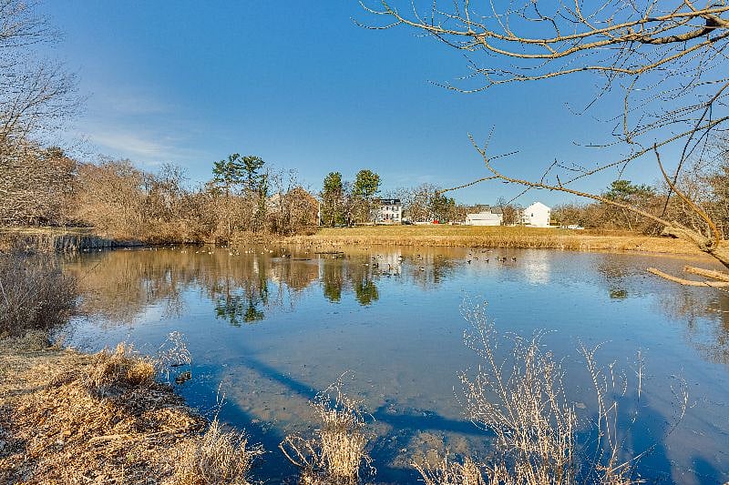 a pond overlooked by a rustic farmhouse, all visible from the property