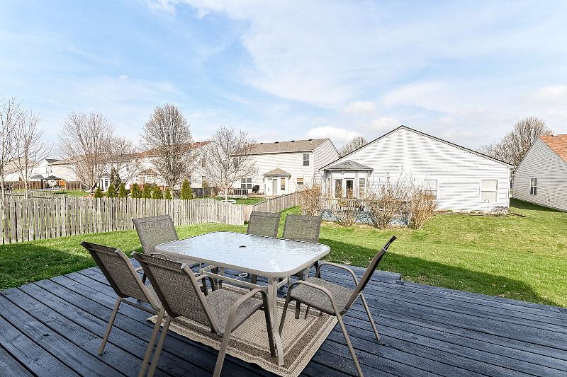 Large back deck with table, chairs, and charcoal grill.