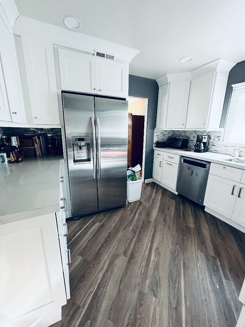 Kitchen view of refrigerator and countertops.