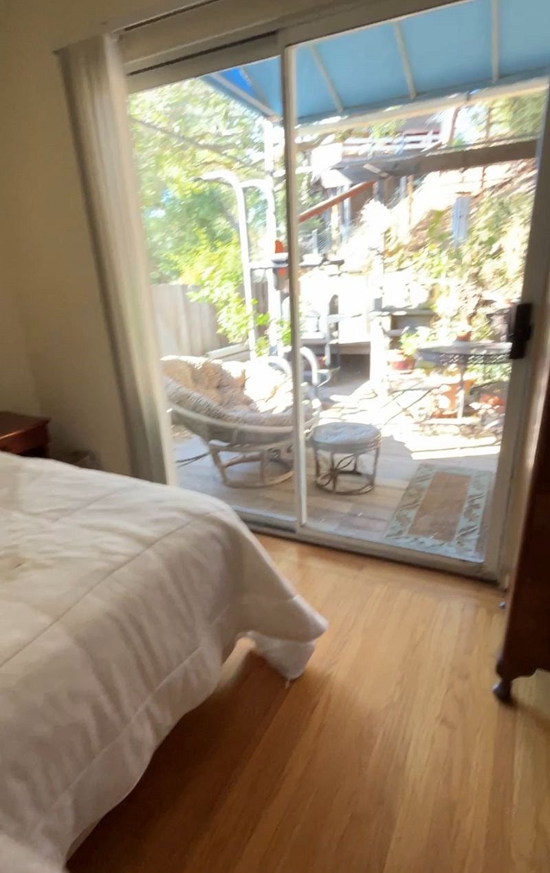 View of deck space for this bedroom. Very sunny back area with bistro table, chairs.