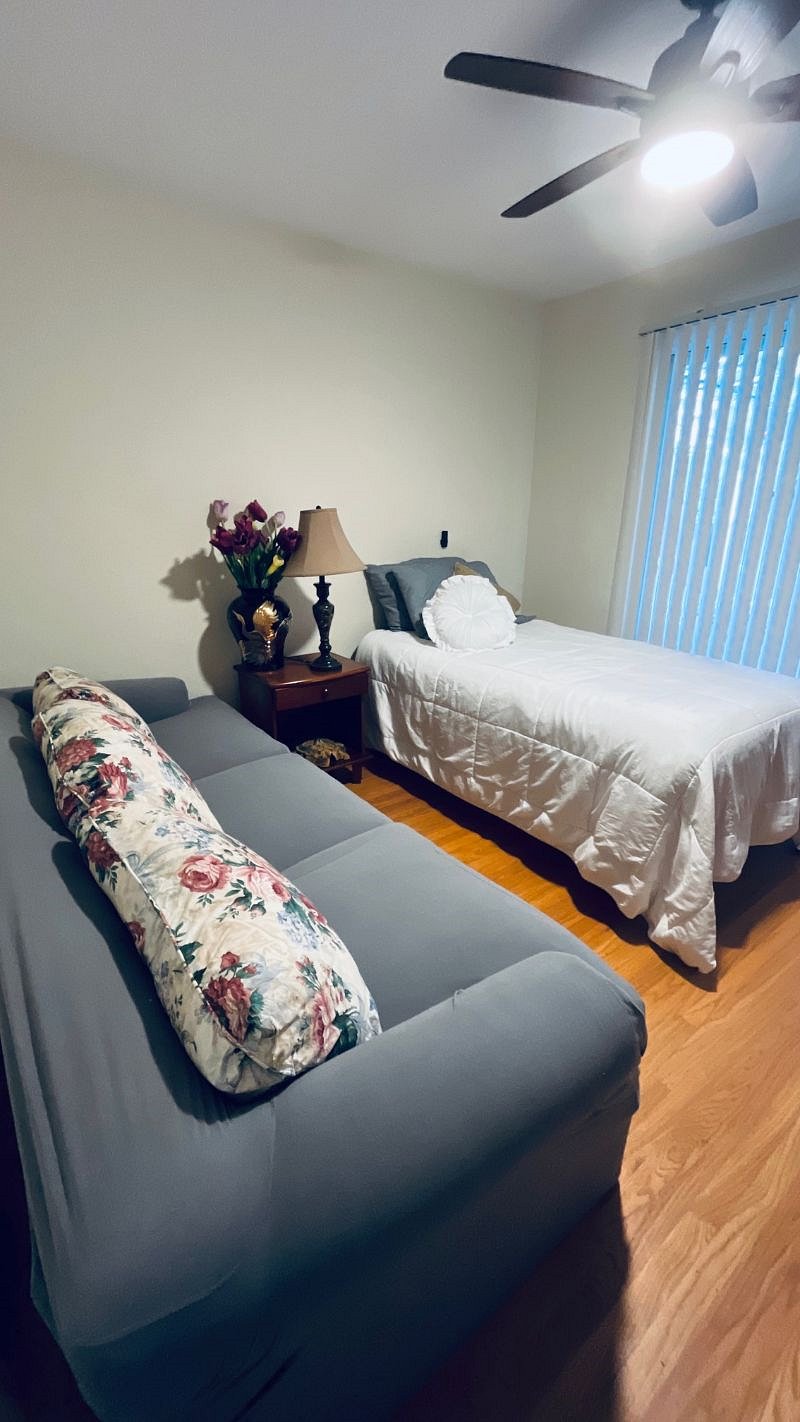 2nd bedroom has a single twin bed with sofa, dresser, sliding door to deck.