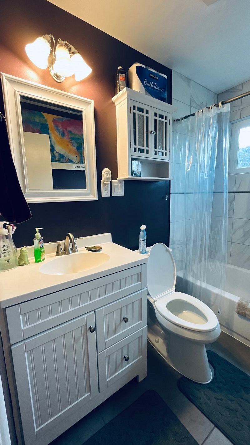 Private bathroom with shower and tub and cabinets.