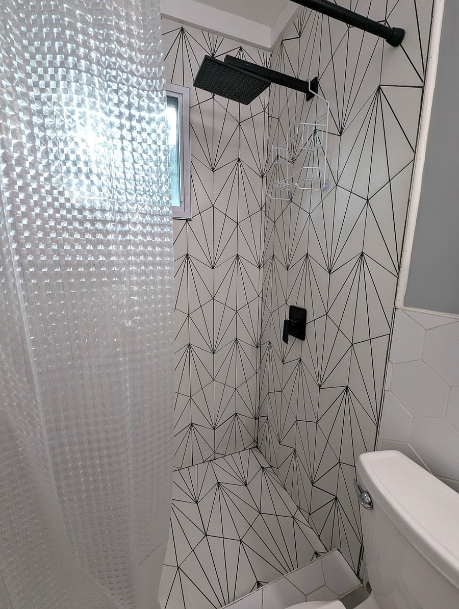 Newly renovated bath with custom tile and rainfall shower.