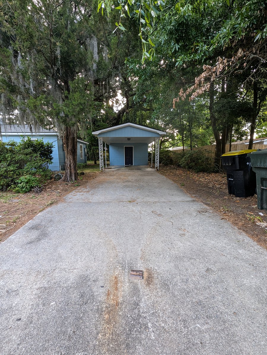Fully covered parking with a lockable outbuilding for extra storage.