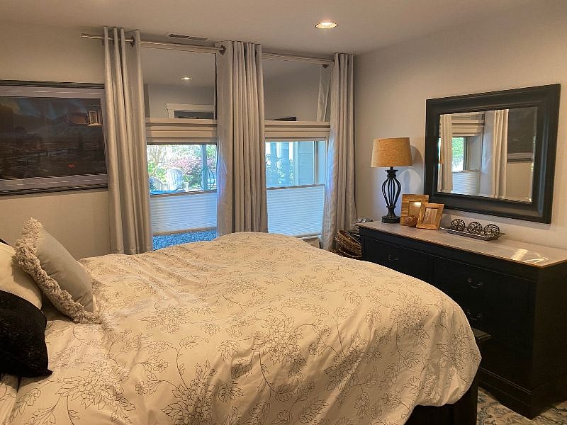 bedroom with full size dresser and two night stands. Up/down shades for privacy