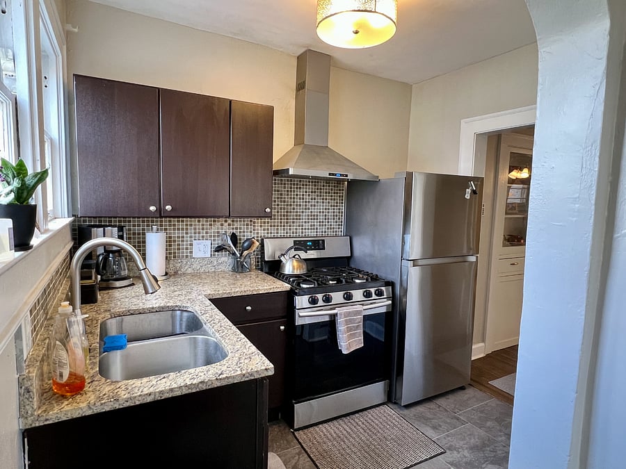 Full kitchen with gas stove and stainless appliances.