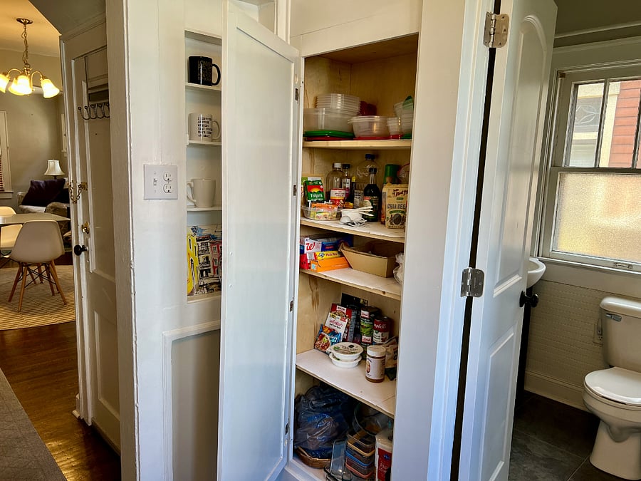 Pantry, stocked with plenty of essentials, including baking items, storage, and spices (more by stove).