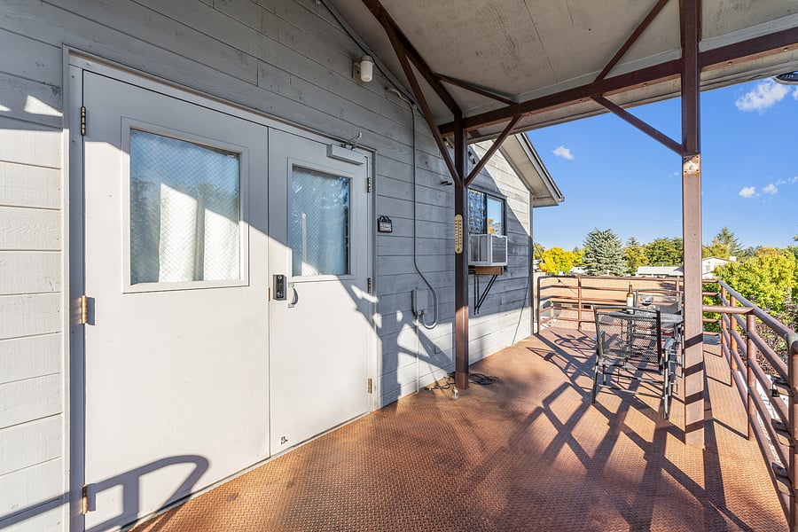 Front door to this unit and outdoor eating area on balcony.