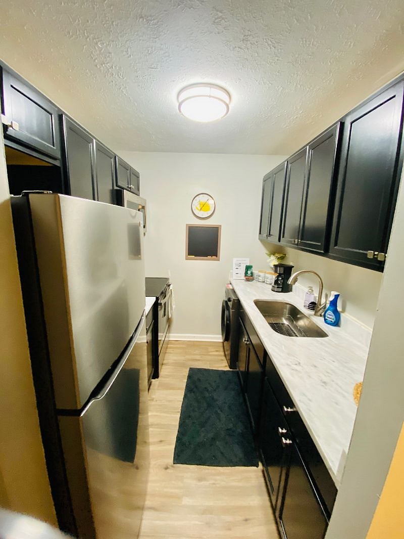Stainless steel appliances includes electric stove, full size refrigerator and microwave with toaster and coffee maker