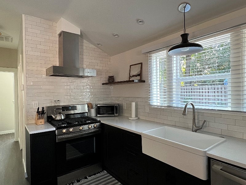 5-burner gas stove, dishwasher, microwave, quartz countertops and farmhouse sink.