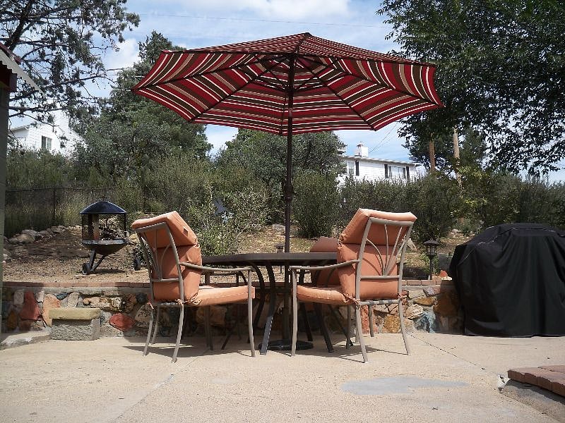 Large, fenced backyard with patio dinette table, 4 chairs and umbrella.