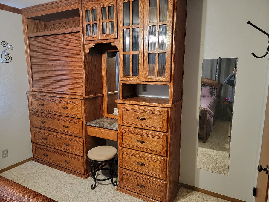 Larg built-in dresser/vanity with concealed TV. Wall mirror.