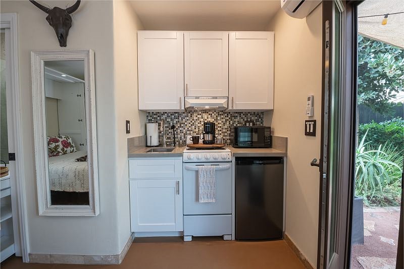 Kitchenette includes cooktop and stove, microwave, sink and mini fridge. There is also a coffee maker and toaster. Cabinets store the dishes, glassware, cups and cooking utensils with additional room for food storage.