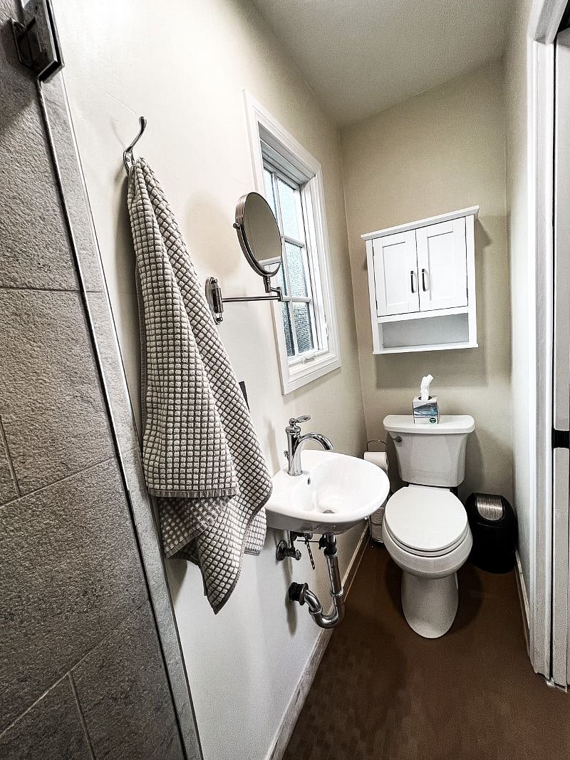 Bathroom view from shower. Wall cabinet and shelf provide good storage. Pocket door provides privacy.