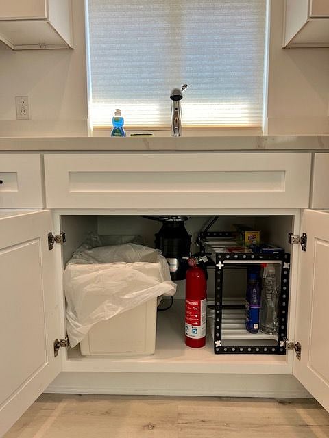 Fire extinguisher and first aid kit is located under the kitchen sink