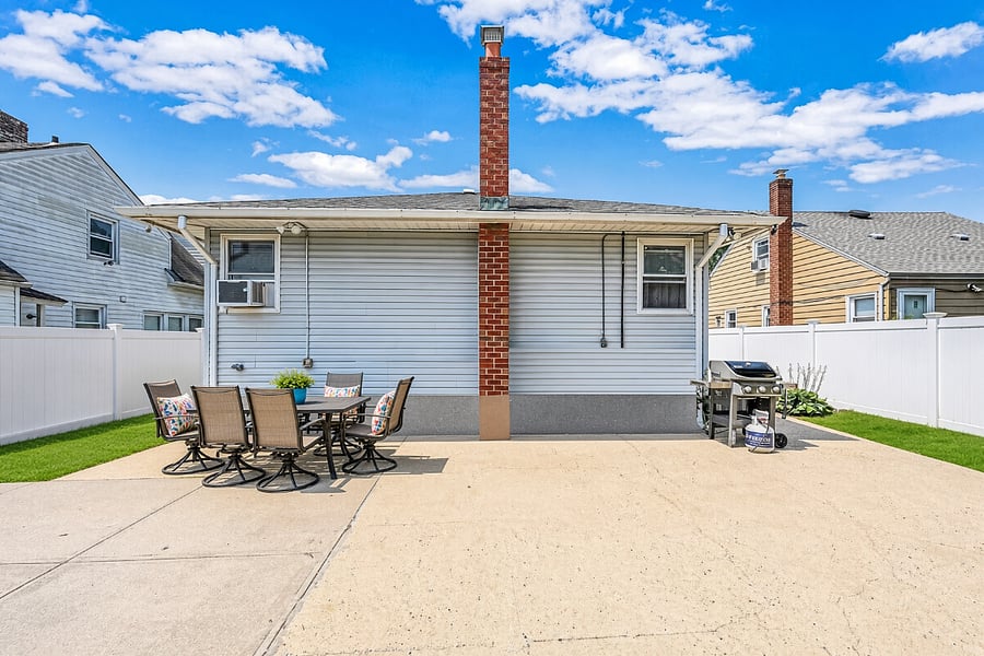Fenced backyard with patio dining set and grill
