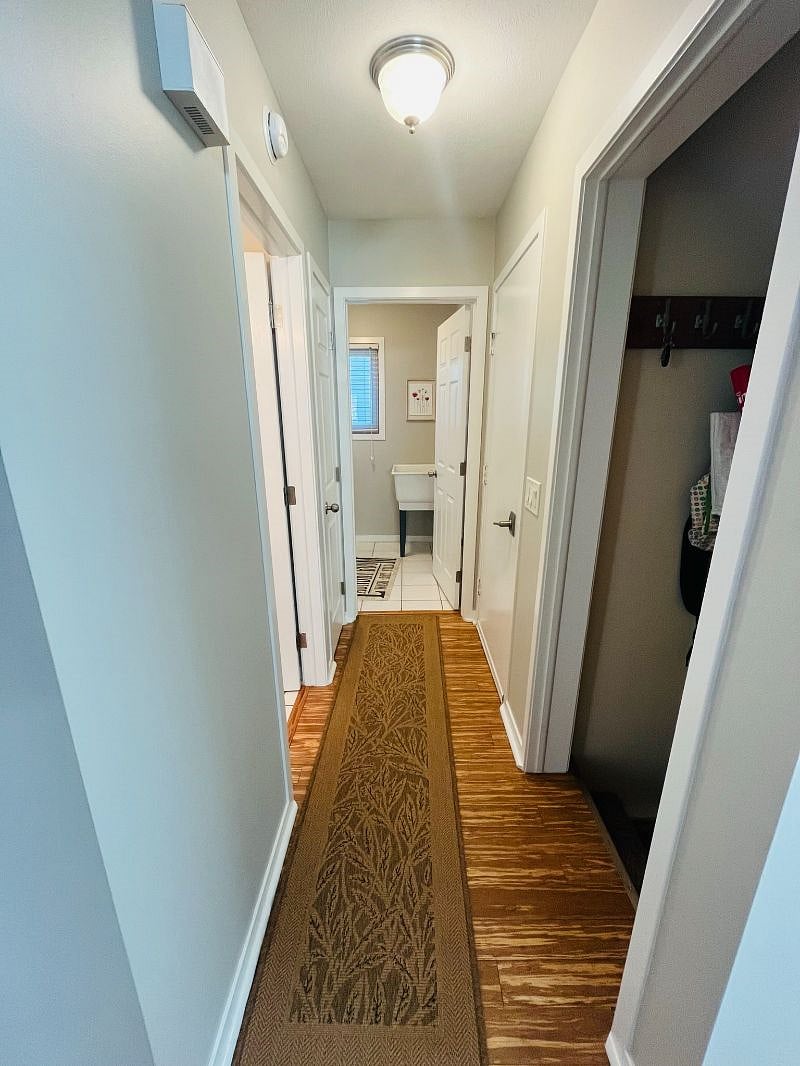 In the main level hallway, the half bathroom is on the left, with the laundry room ahead. On the right, there's a service door to the garage.