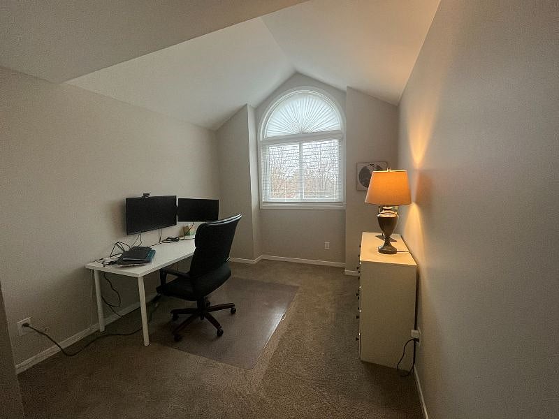 One of the two offices includes a dresser, desk, office chair, and wall-mounted monitors for a functional workspace.