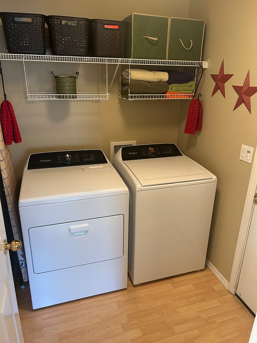 Laundry room adjacent to the kitchen with full size washer and dryer.