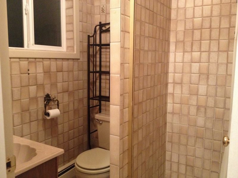 The bathroom has a shower and cozy heatlamp, fully tiled.