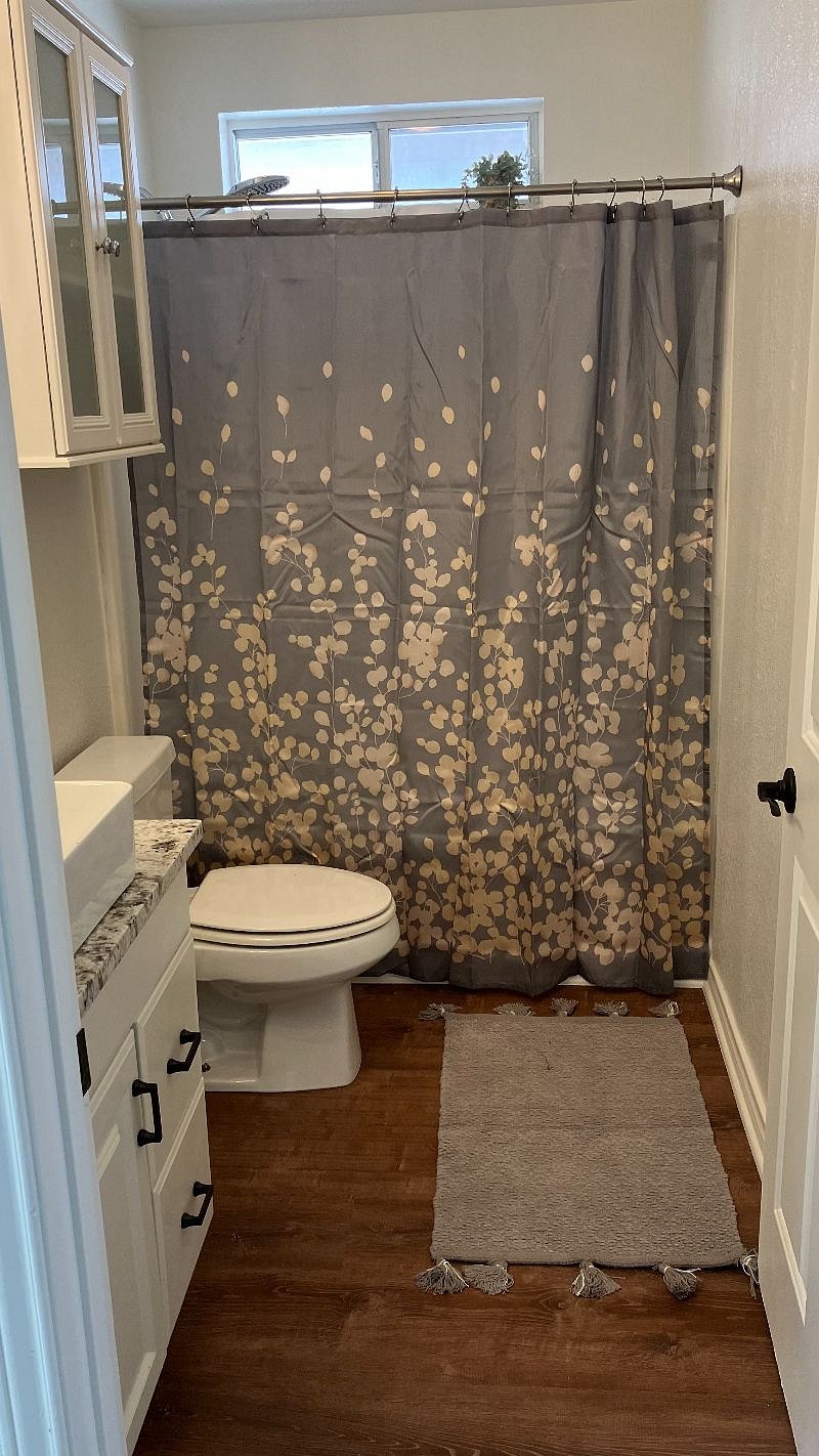 The full bath in the upstairs bathroom features a handheld rainhead shower.
