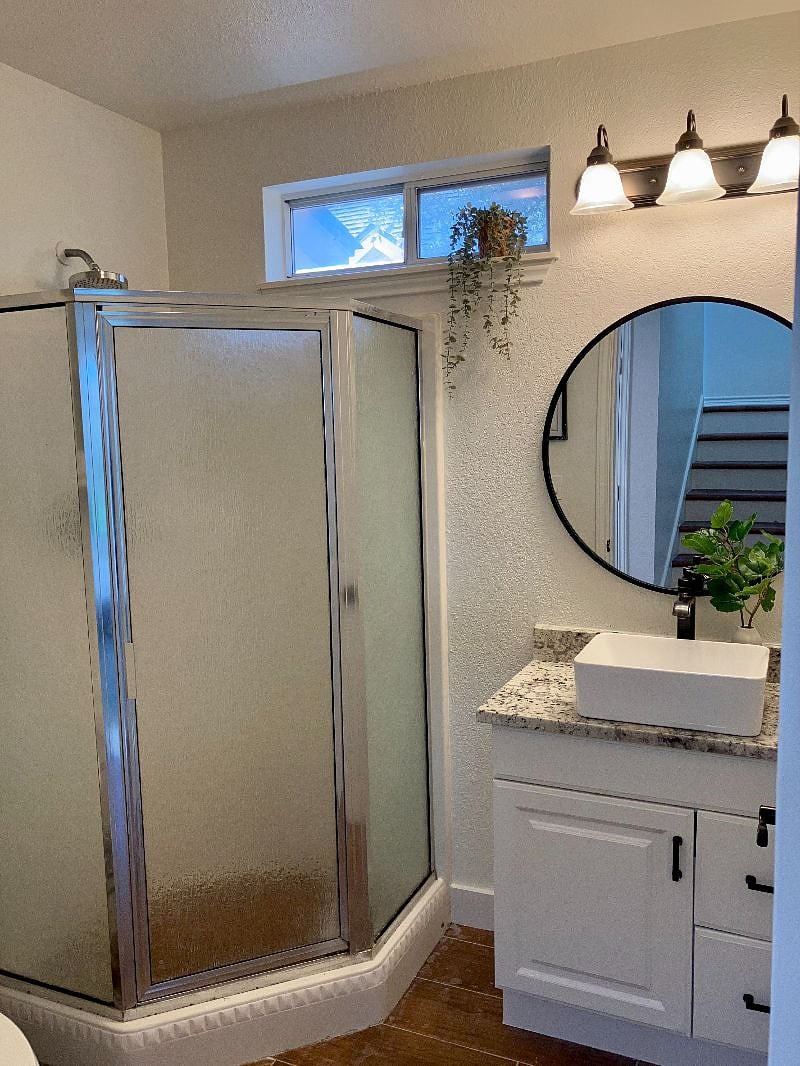 The first-floor master bathroom features a walk-in rainhead shower.