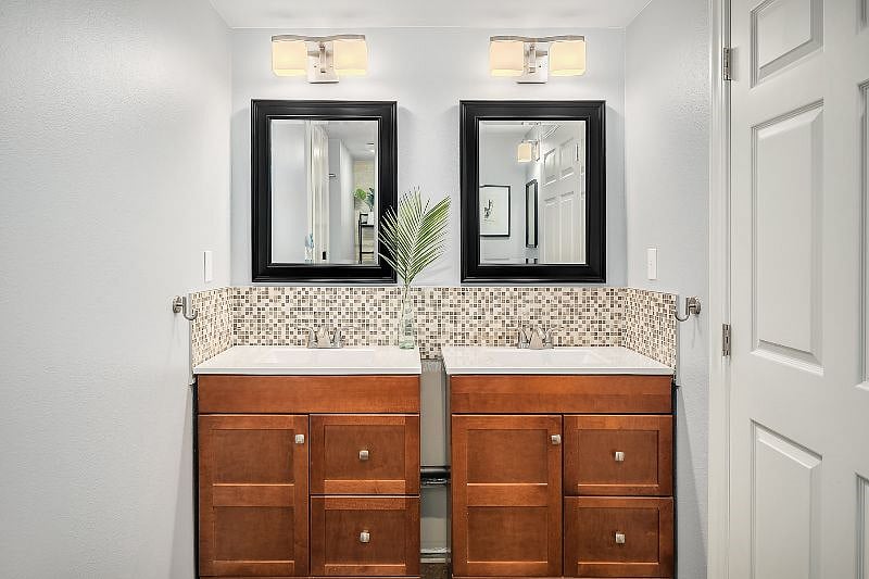 Double vanities in roomy full bathroom with two full drawers in each for ample storage capacity.
