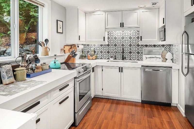 Fully equipped kitchen with quartz countertops, electric stovetop and oven, microwave, dishwasher, fridge/freezer and a multi-windowed view to the terraced gardens. Concrete tile backsplash, and deep stainless sink, and large corner lazy Suzan cabinet offers built in pantry space in addition to the other cabinet storage. Lots of great light in this kitchen/living room area!