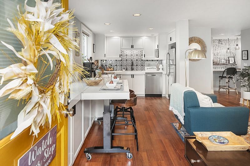 Entryway to the living room, moveable eating bar, and full kitchen