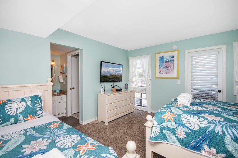 Master bedroom with queen size bed and twin size bed. Bedroom has a TV