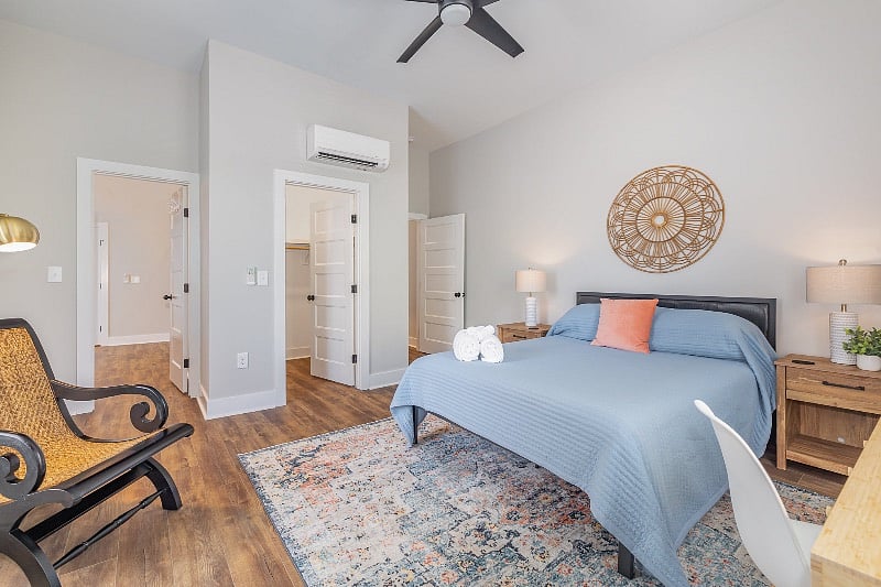 Spacious, light-filled bedroom with queen sized mattress, TV, dresser, walk-in closet, dedicated desk space and en-suite bathroom.