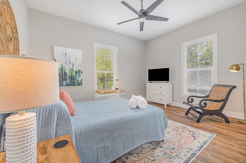 Spacious, light-filled bedroom with queen sized mattress, TV, dresser, walk-in closet, dedicated desk space and en-suite bathroom.