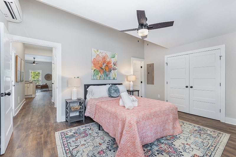 Large bedroom with queen-sized mattress, ceiling fan, large closet, dresser, TV and direct access to the bathroom.