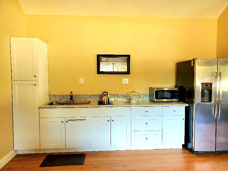 Kitchen includes full size fridge (with icemaker and water), 2 burner stove, microwave, coffee maker, toaster oven/air fryer combo. And of course all plates, silverware, etc are ready for you.
