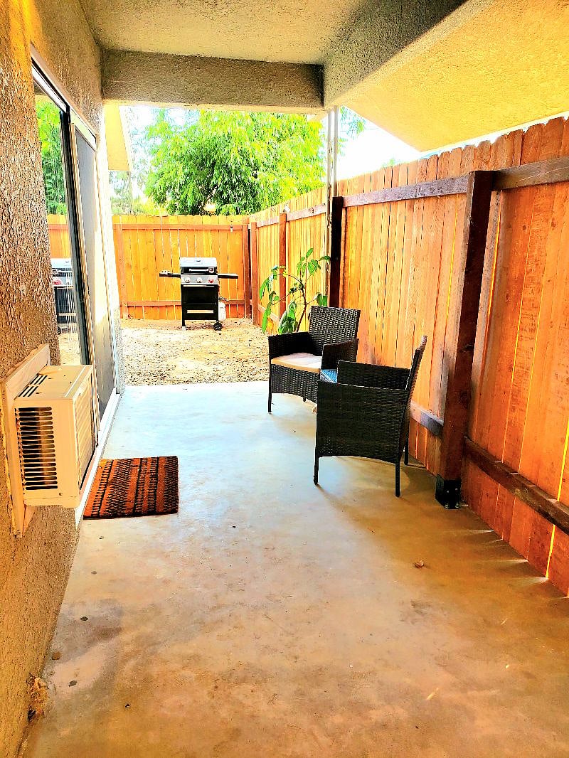 Private outdoor patio with seating area and grill