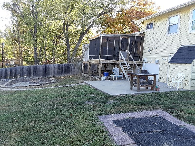 Back yard. Fully fenced. Patio, screened in deck, sunken stone patio w/ firepit. Access walkout from lower level or main level & down deck stairs.