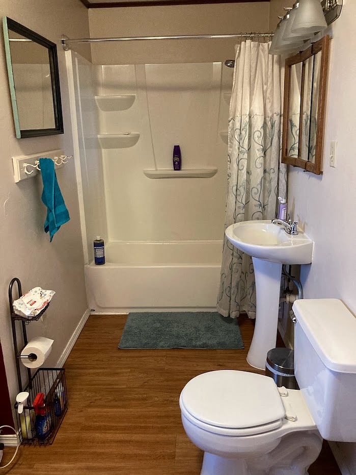 This is the full downstairs bathroom, around the corner from the Living roomm and next to the downstairs bedroom - there is a tub, sink and toilet on one side and the laundry room on the other side with washer and dryer.