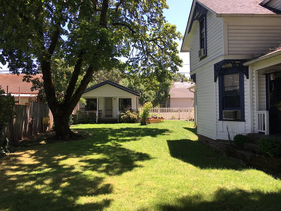 This is the street view of the north side yard - photo taken in the summer when there were lots of leaves on the trees - you can also see the cottage to the back and north of the property - this dwelling has it's own yard and entrance through the back/alley. 