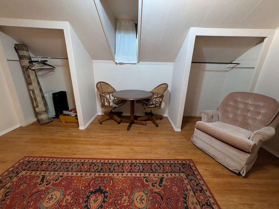 Two closets on either side of the table and chair set with a dormer window.