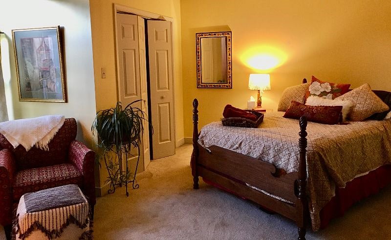 Soft yellow painted bedroom is 10 x 12 furnished. Double bed with desk.