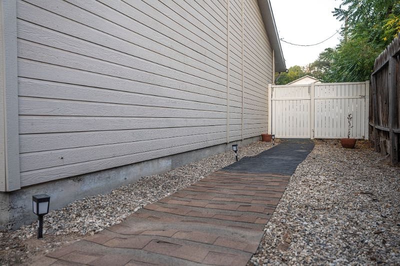 The walkway from the parking (behind white fence) to the tiny home.